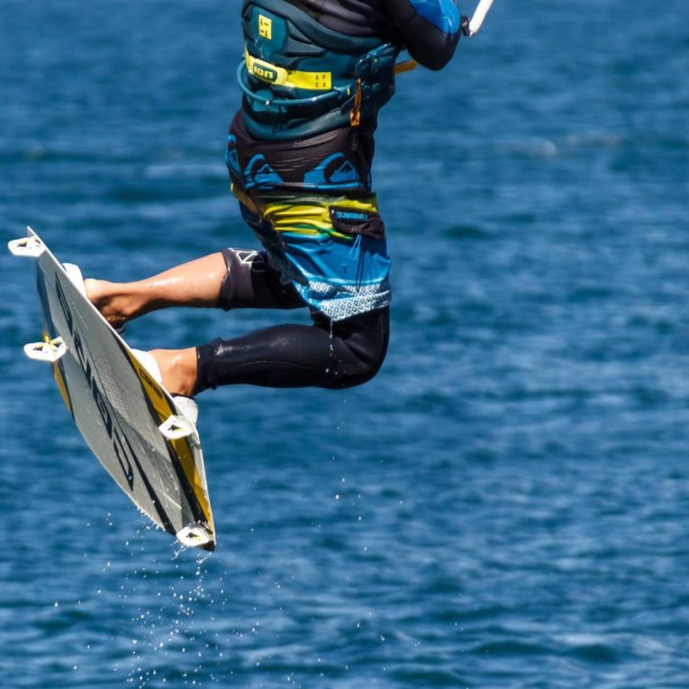 A man kiteboarding in the ocean, enjoying the thrill of the sport while harnessing the power of the wind and waves.