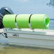 Image of a white FM floating mat storage rack carrying a green and blue floating mat on the back of a boat in the ocean.