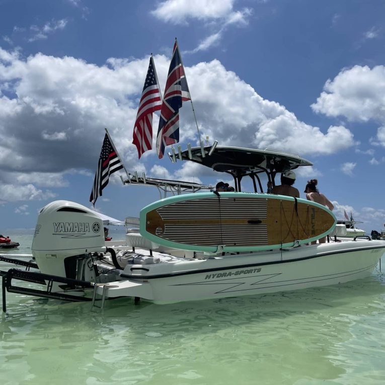Manta Racks S2 Jun 10 2023, 11 48 29 AM People in a boat on the water, with surfboard stored in the Manta Racks S2 storage rack.