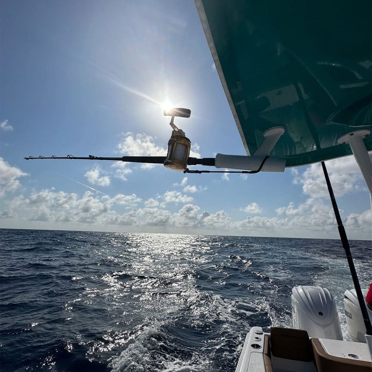 Rod-&-Reel-Leash-Boat A boat in the ocean with a fishing rod and reel, equipped with Manta Racks Rod & Reel Leash.