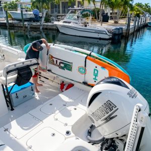 Paddleboard secured on a rack aboard a center console boat at a Florida marina as a boater loads gear